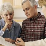 professionals explaining terms to an old couple